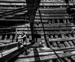 Wood piece is being lifted while the worker inspects it