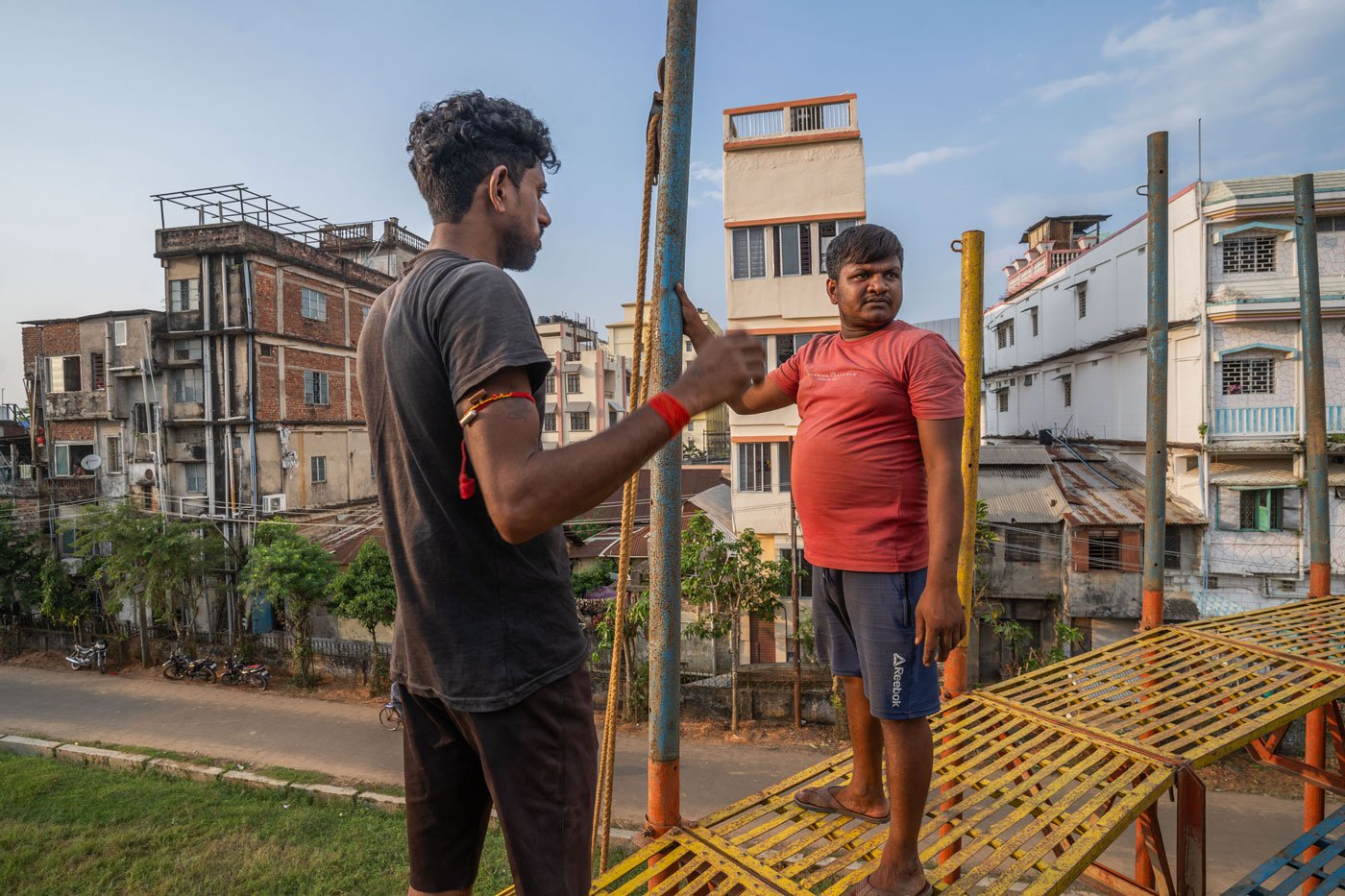 The riders are also the ones setting up the well-like structures. Here Pankaj Kumar (left) and Rubel Sheikh (right) are working on the set-up for a mela for Durga Puja in October 2023 in Agartala, Tripura