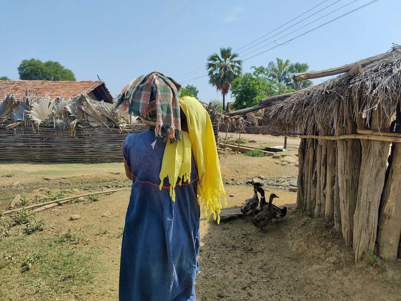 Saru tries to calm her restless son (under the yellow cloth) outside their home in east Gadchiroli, while she worries about having to go to the kurma ghar soon.