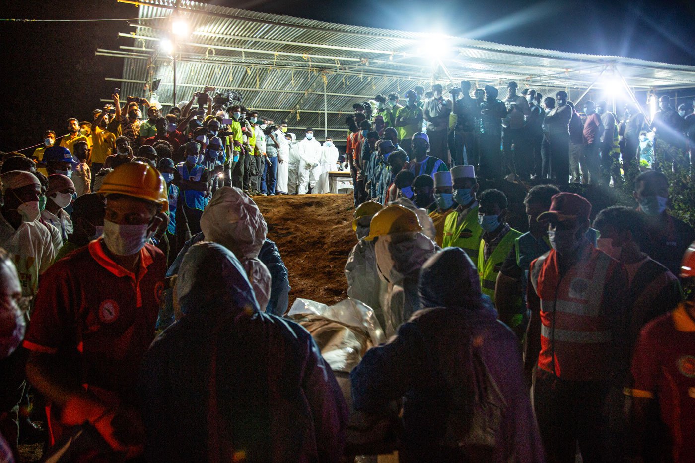 The bodies are carried to a prayer hall where people from all religions have gathered to offer their prayers for the deceased