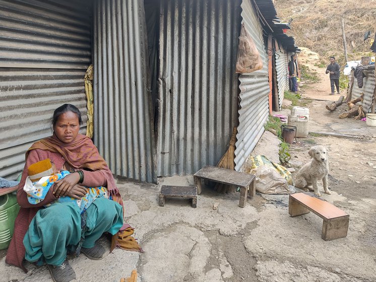 Anuradha sits with six-month-old Sanju, outside her room.