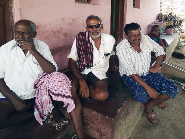 Three farmers and a woman sitting in the front of a home