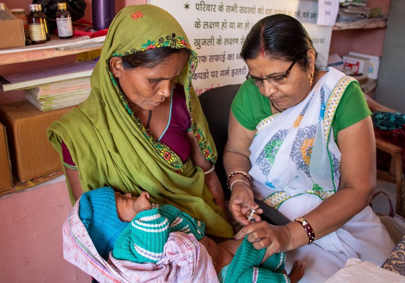 Niranjana Joshi, the ANM at the health sub centre administers the first ever vaccines to Hira Ninama’s fifth daughter