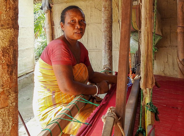 Sama seated at her bamboo pedal loom