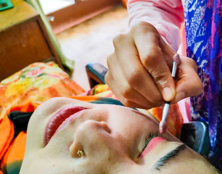 Renu Thakur (left) has been in the beauty business for 11 years, starting when she was 21. Applying a thin layer of foundation on her customer Jyoti’s face (right), Renu strokes the brush around her eyes. 'This cream will make the skin smooth so that the make-up has a better glow,'  she says