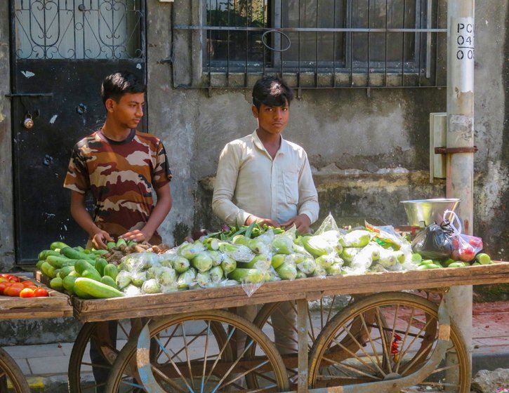 Mubarak Sheikh and his brother Muzzafar (in white) have been trying to juggle attending online classes and selling vegetables on a handcart