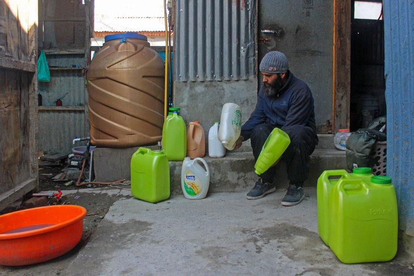 Right: Mushtaq Ahmad Gudoo checking plastic cans (left) which his family has kept for emergencies