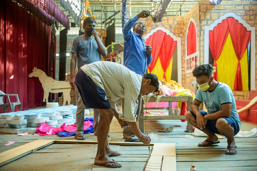 Ramesh Dutta (left) shows a hand-drawn set design for the Raas Mahotsav. In the auditorium of the Garamur Saru Satra, he gets the set ready for the 2022 Raas performances