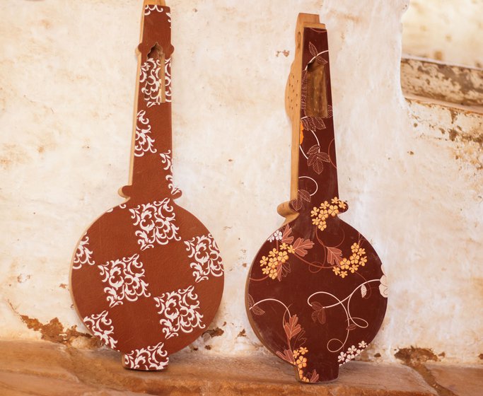 Anoparam also handmakes kamaicha and sarangi (left), popular musical instruments of Jaisalmer. He also makes doors on which he carves flowers (right). Anoparam takes almost a week to make one such door