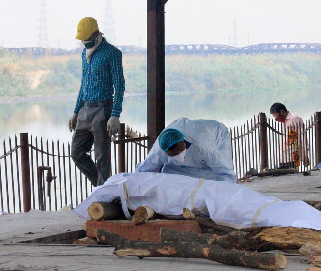 Left: A body being prepared for the funeral pyre. Right: Water from the Ganga being sprinkled on the body of a person who died from Covid-19