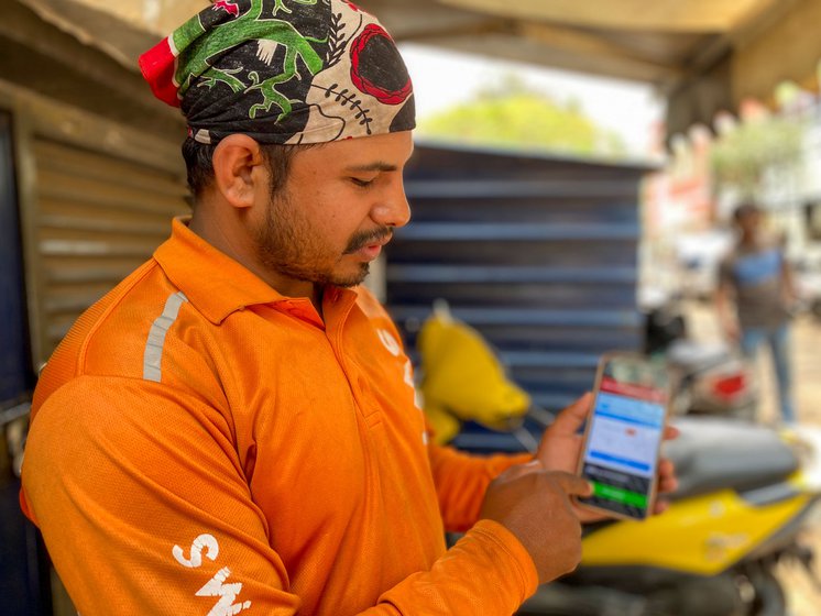 Right: Sunder Bahadur Bisht showing how the app works assigning him his next delivery task in Bangalore