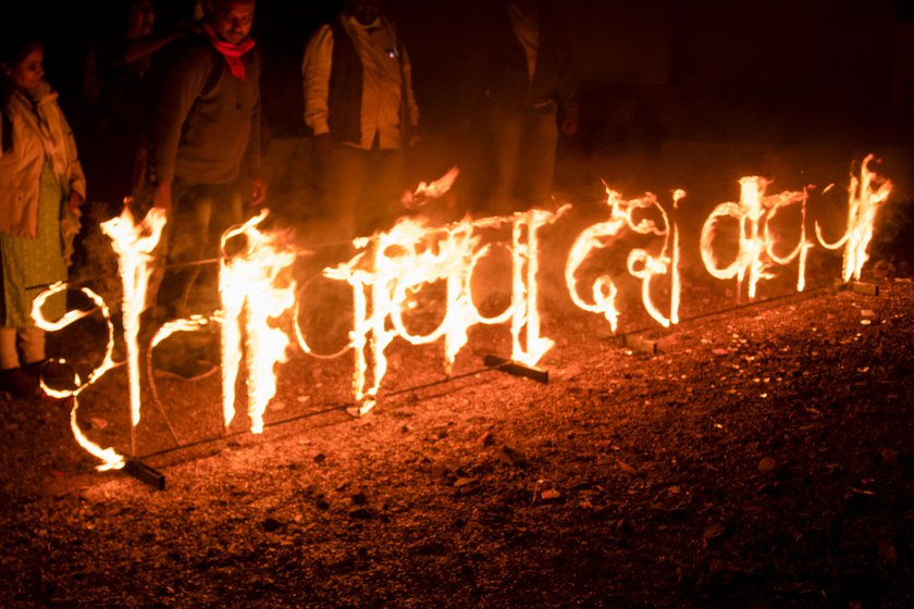 Left: Many had packed a simple meal from home for dinner. Right: At night, the protestors lit up the slogan 'Save Farmers, Save Nation'