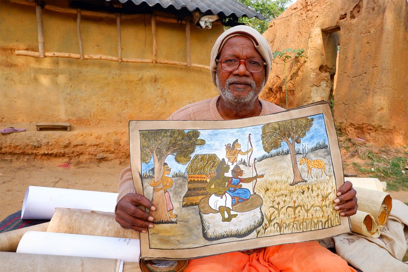 Anil Chitrakar, the oldest Paitkar artist in Amadobi village, with his paintings