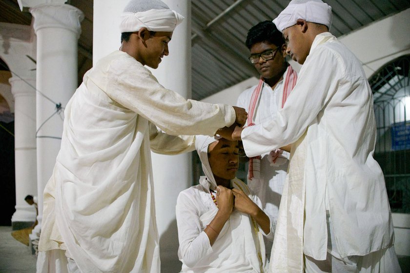 Left: Priyabrat Hazarika (left), Subhashish (right) and Xuruj Jyoti Borah (centre) help fellow bayan Nabajyoti Borah (sitting) tie his paag .