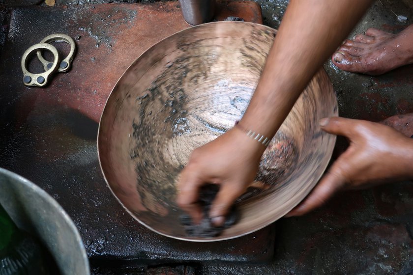 Sunil rubs tamarind on the kadhai to bring out the golden shine. He follows it up after rubbing diluted acid