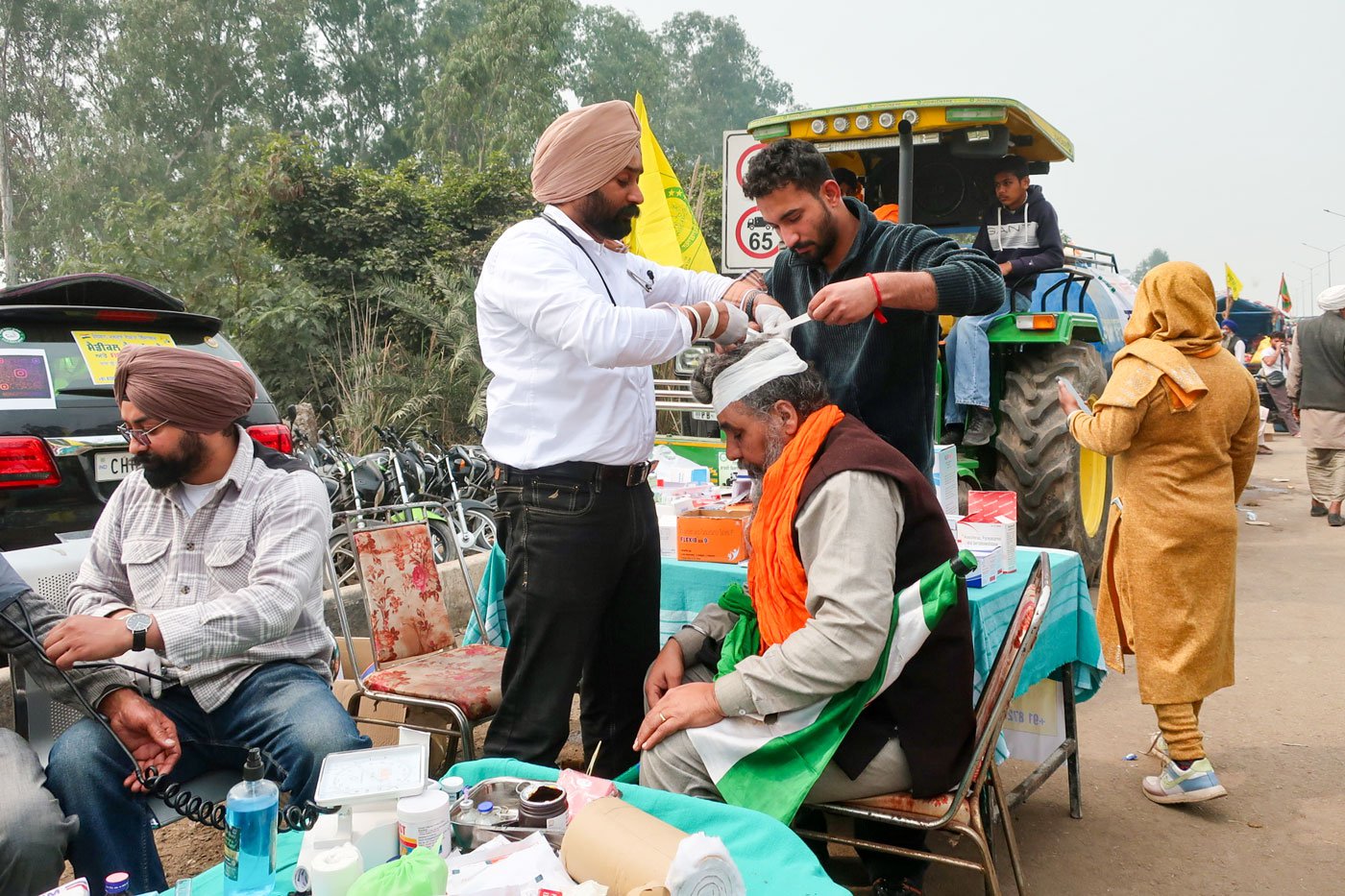 Right: Dr Mandeep Singh attending to Jarnail Singh who was hit in the head during a lathi charge and had to get five stitches