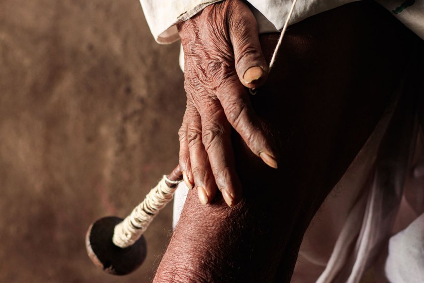 Siddu uses cotton thread to make the jali . He wraps around 20 feet of thread around the wooden takli , which he rotates against his leg to effectively roll and thicken the thread. The repeated friction is abrasive and inflames the skin