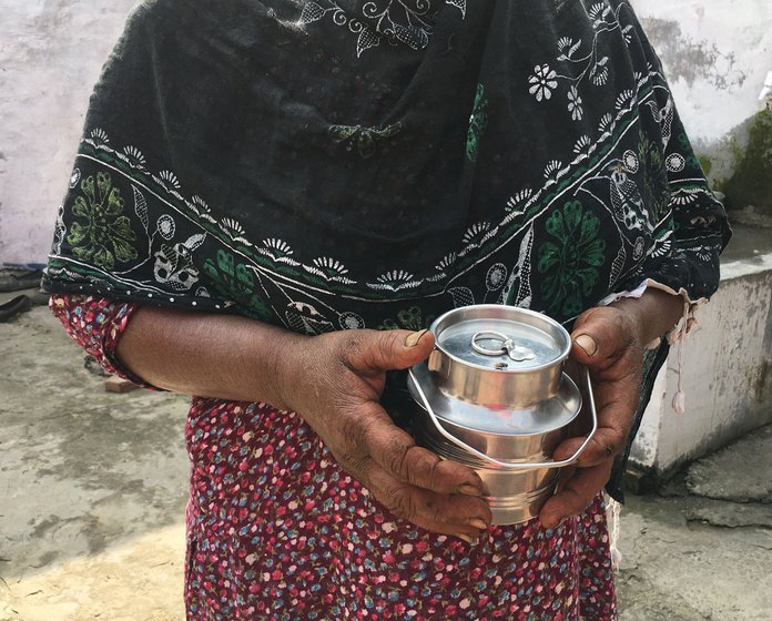 Manjit Kaur at home with her grandson (left); and the small container (right) in which she brings him milk. Manjit had borrowed Rs. 4,000 from an employer to buy clothes for her newborn grandson and for household expenses. She's been paying it back with the grain owed to her, and the interest in cash