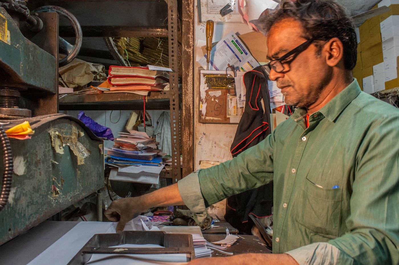 S. K. Sheikh the owner of Taj Envelopes arranging the die on the rectangle sheets before cutting the paper in the machine