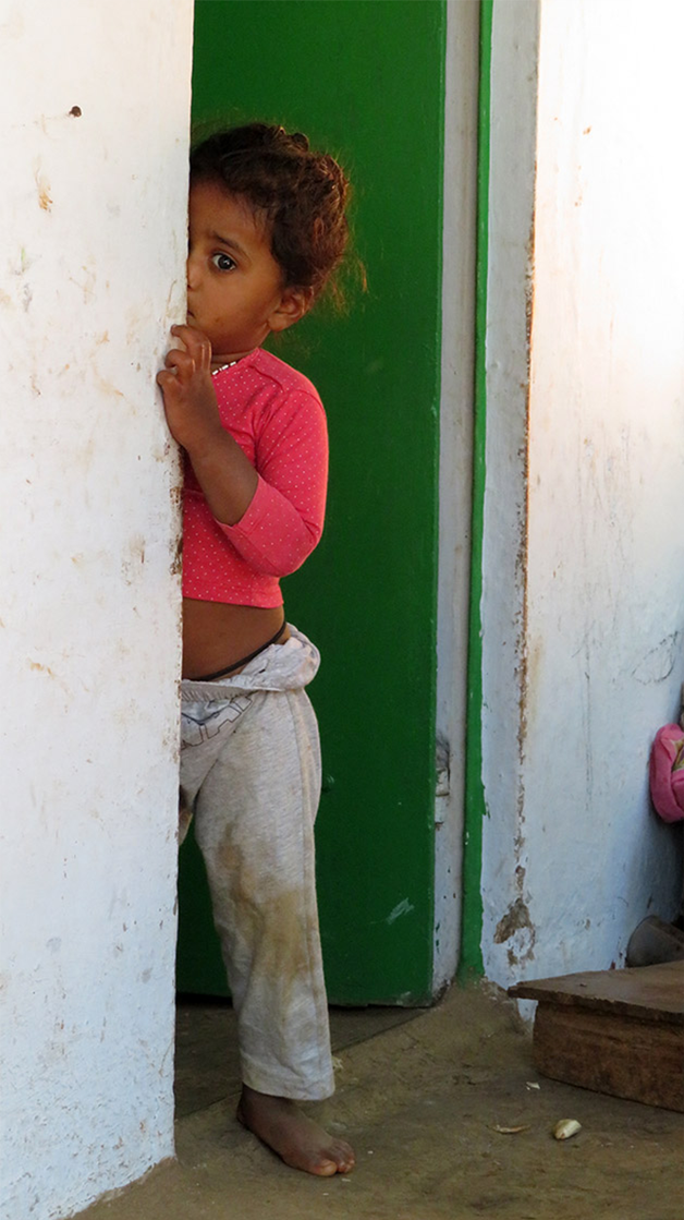 Krishna's daughter Gita peeps shyly around a doorframe