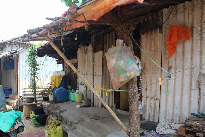 Outside their home in Umela village. Suman’s mother, Nanda (right) making a broom from dried coconut palm leaves.