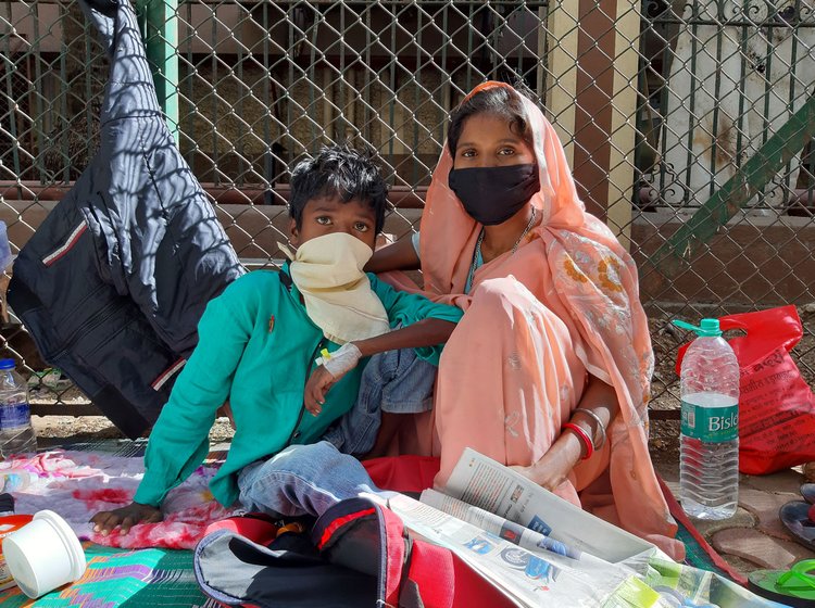 Left: Ajay , a Class 4 student from Jharkhand, arrived in Mumbai with his parents over two weeks ago. Ajay suffers from blood cancer. His father runs around for his reports and medicines while his mother takes care of him on the footpath. Right: People from poor families across India come to the  Tata Memorial Hospital because it provides subsidised treatment to cancer patients

