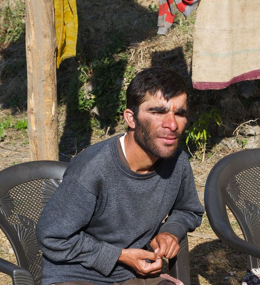 A young man sitting on a chair outdoors