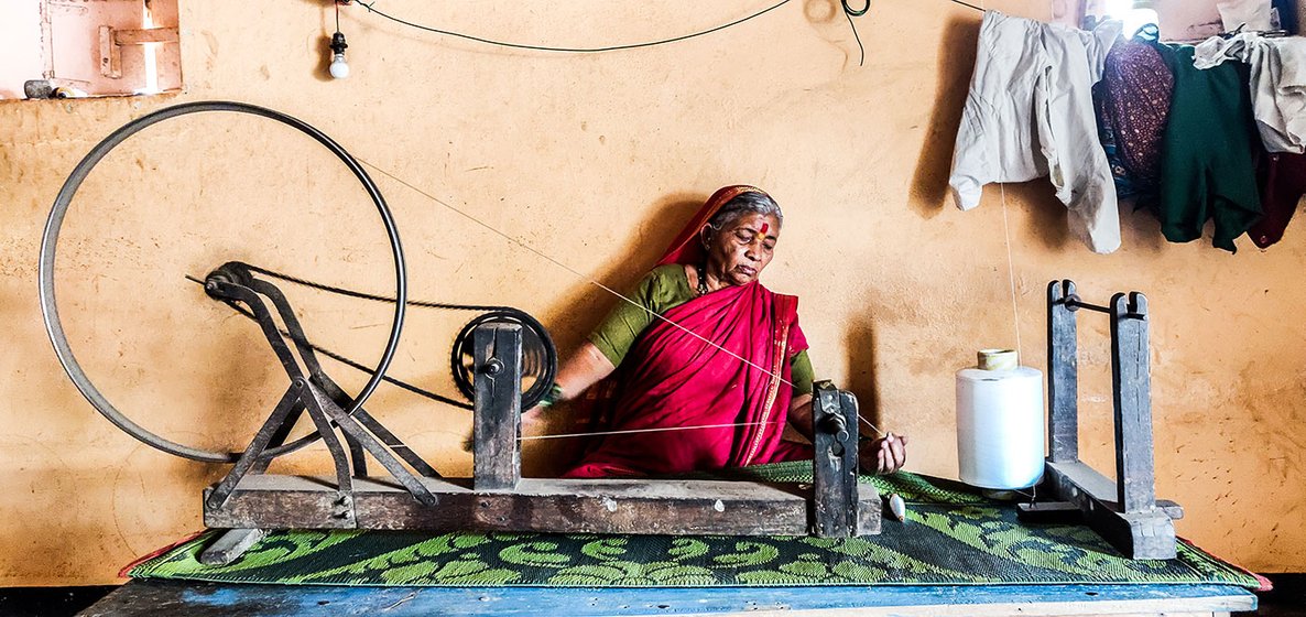 Vimal Tambe hand spinning the polyester thread which is wound on a pirn