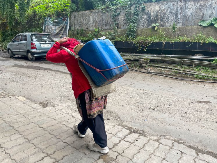 Asti Thami (left) and Jungey Thami (right) carrying water cans for delivery