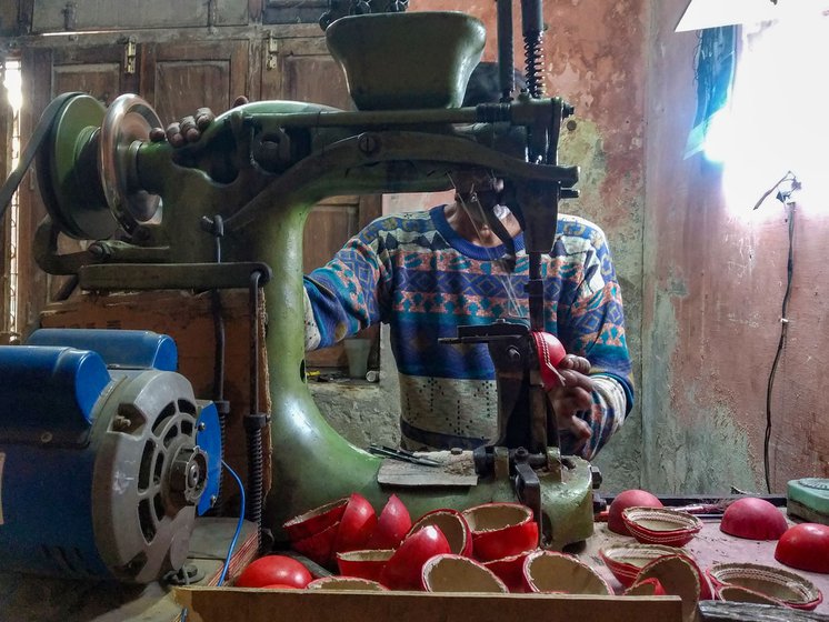 Right: Dharam uses a machine to stitch two parallel layers of seam on each of these hemispheres. Unlike a handstitched seam in the case of a four-piece ball, a machine-stitched seam is purely decorative