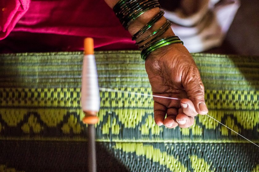 The pirn winding process is usually done sitting on the ground. After an accident, Vimal Tambe sits on a chair to work