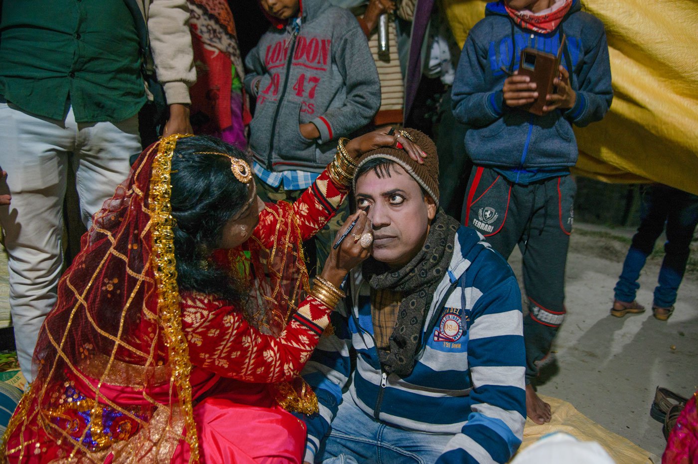 Usharani Gharani lines Uday Mandal’s eyes with kohl; the actor is playing the role of Shah Jangali, the brother of Ma Bonbibi