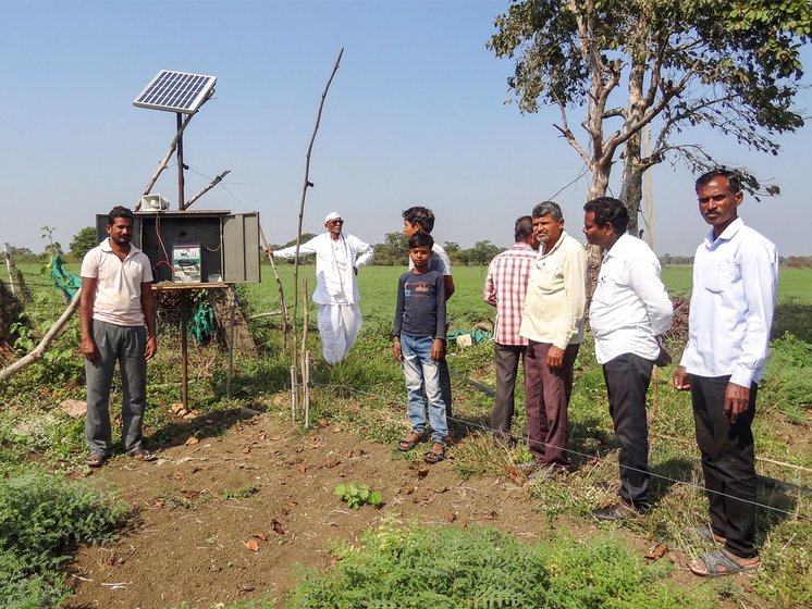 Mahadev Umre, 37, is standing next to a battery-powered alarm which emits human and animal sounds to frighten raiding wild animals.