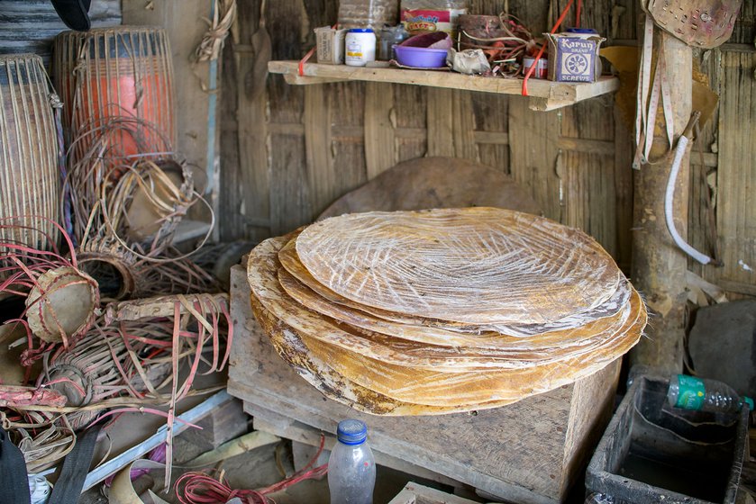 Giripod and Podum cut small sheets from the hide to fit the instruments being worked on. A toolbox holds the many items necessary for preparing the leather: different types of chisels, blades, a hammer, mallet, stones and sandpaper