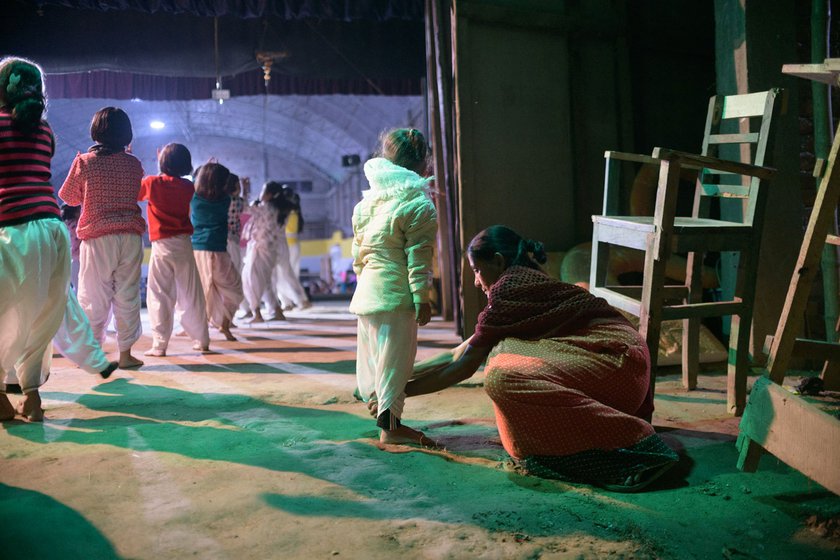 Right: Children rehearse for their roles as gopa balaks [young cowherds]. A mother fixes her child's dhoti which is part of the costume