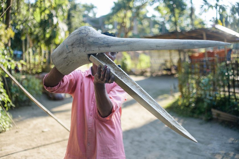 Right: He demonstrates how he designed a movable beak for a crane mask.