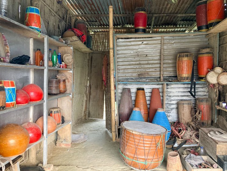 Left: Surrounded by other musical instruments, a doba (tied with green thread) sits on the floor awaiting repairs.