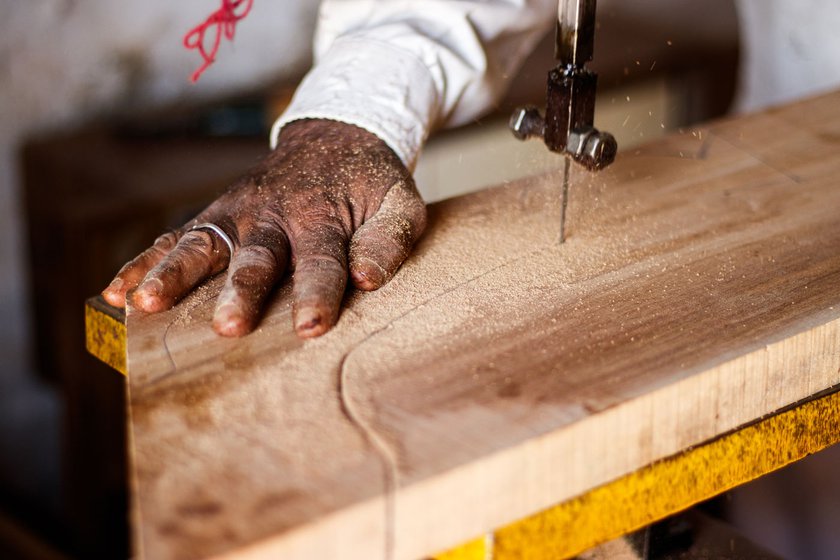 Right: Anoparam cutting a wooden block which will be used to decorate the door