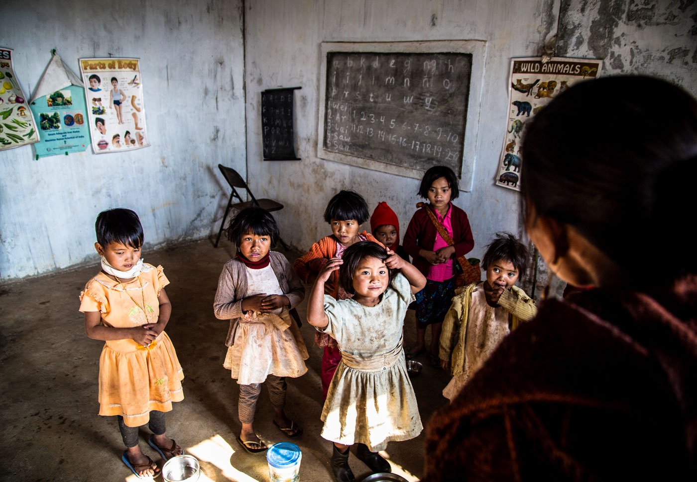 The teacher asks the children to recite a rhyme; Kynja leads the group