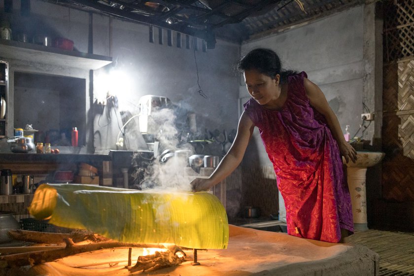 Nayamoni smoking the eel in a banana leaf