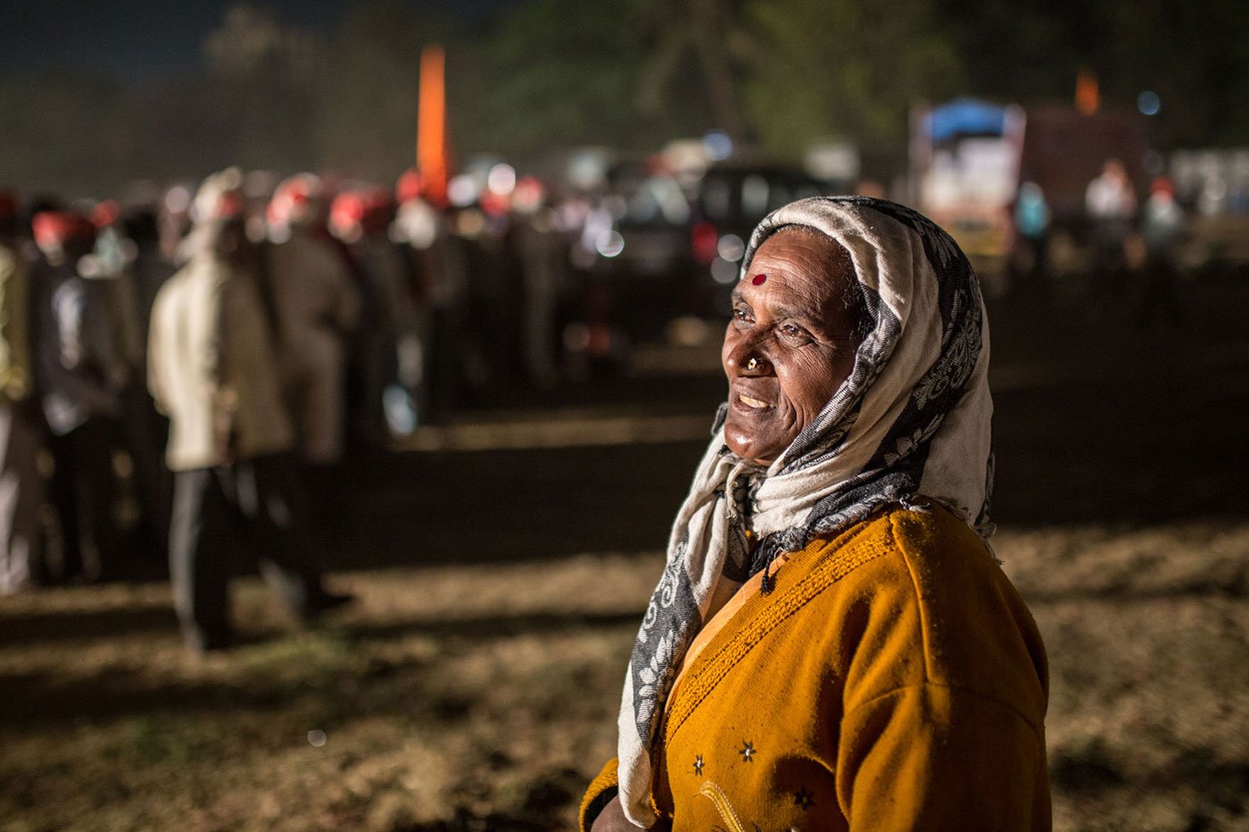 A woman with her head covered standing at Somaiya ground, Mumbai, at night