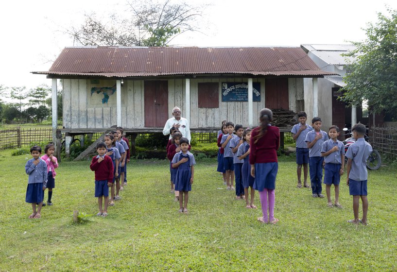 Students lined up in front of the school at the end of day and singing the national anthem.