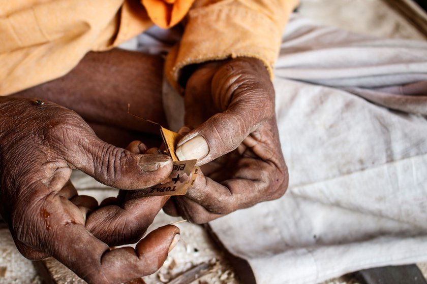 Left: Narayan shapes the folded cane leaf into a reed using a blade.