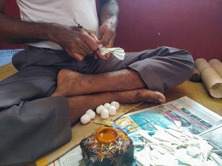 Holding each feather by the quill, grafting expert Tapas Pandit dabs the bottom with a bit of natural glue. Using a shonna (tweezer), he fixes each feather into the drilled holes one by one, making them overlap.