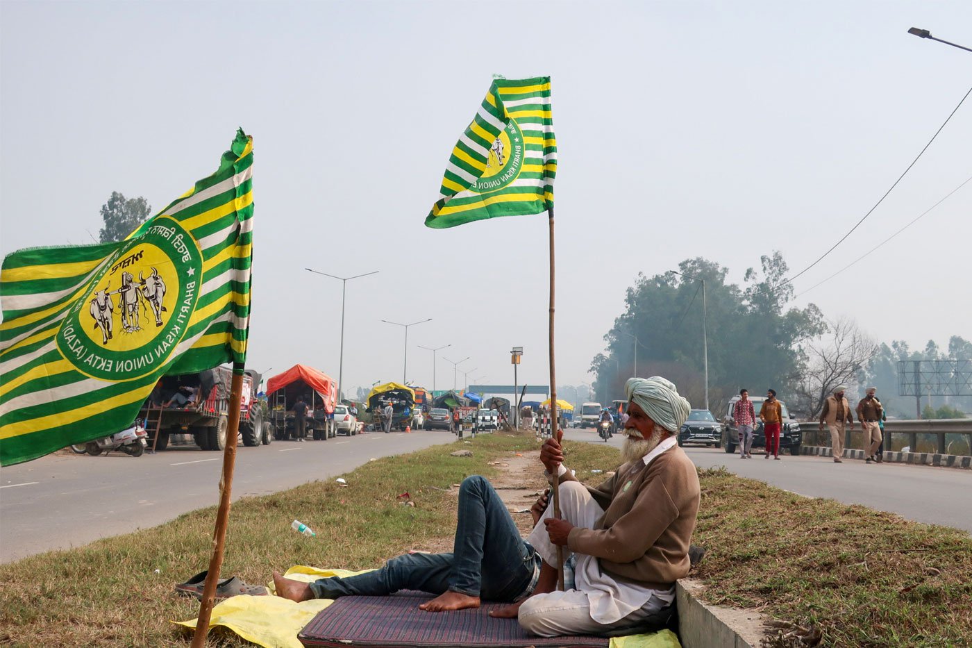 An elderly farmer sits with his union's flag