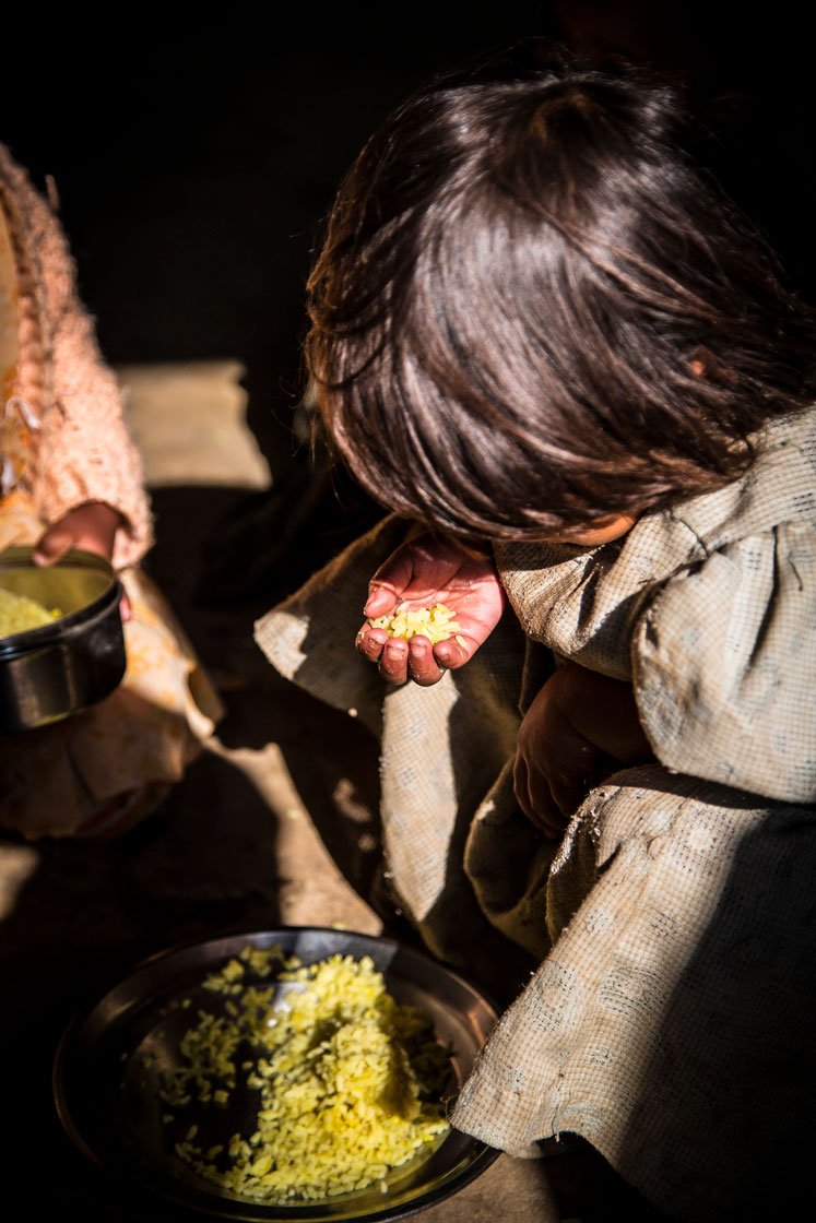 Kynja Babha (right) finishes her meal. Her day at the anganwadi has come to an end