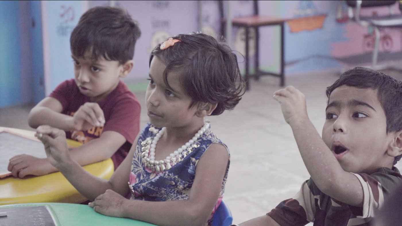 Students learning to make signs for the Marathi alphabet