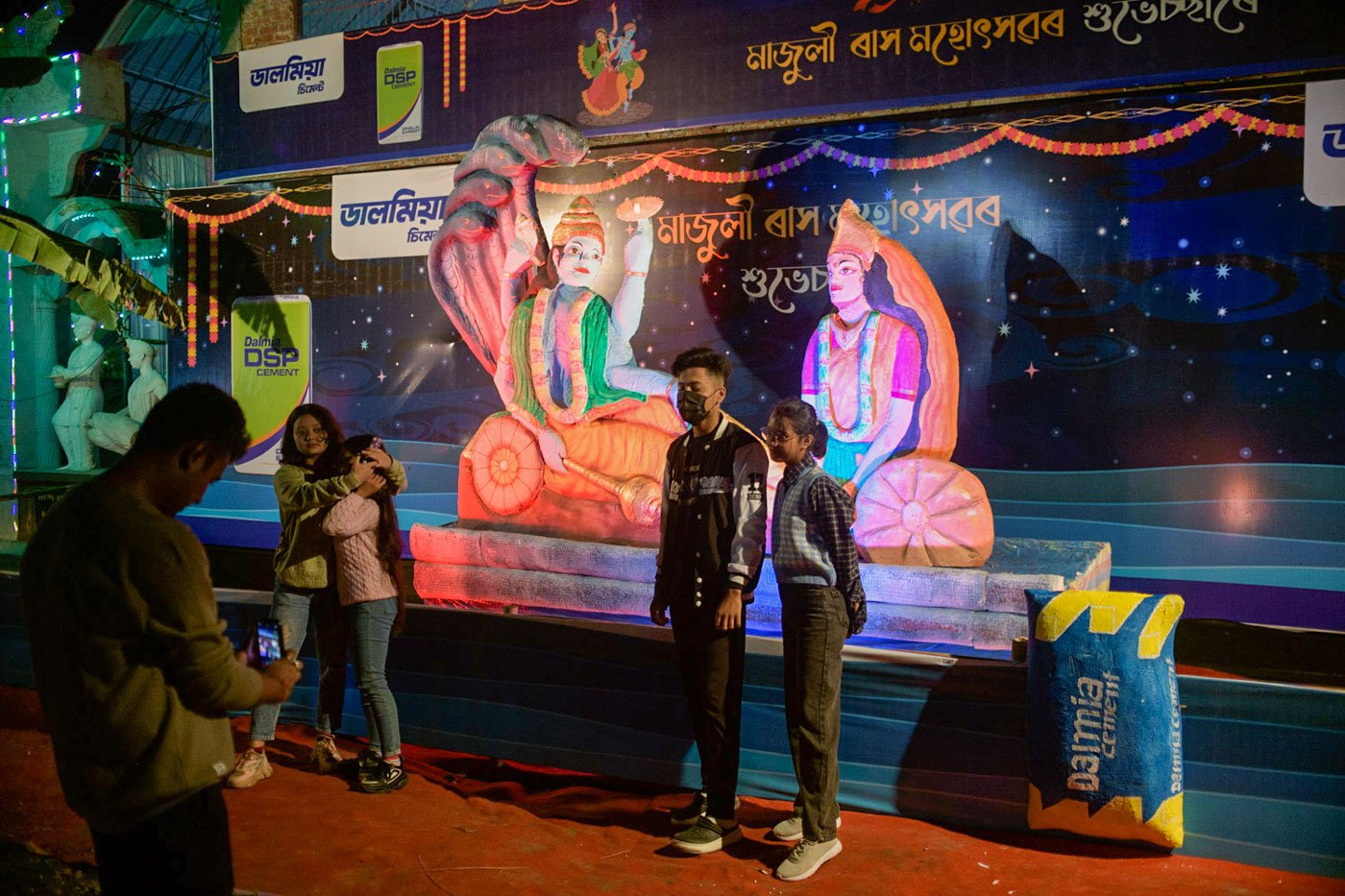 People take photographs near the gates of the Garamur Saru Satra