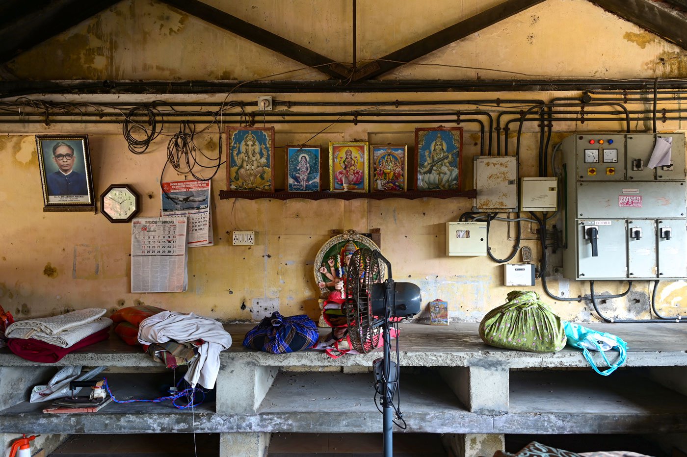 The ironing shed adorned with pictures of gods