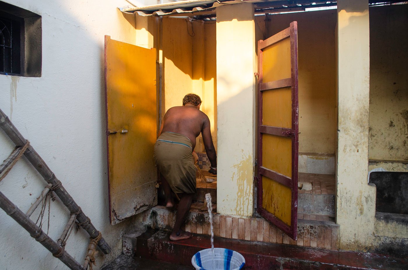 Pandi cleaning public toilets without safety gear. His earning ensure that his children get an education; today they pursuing their Bachelors.